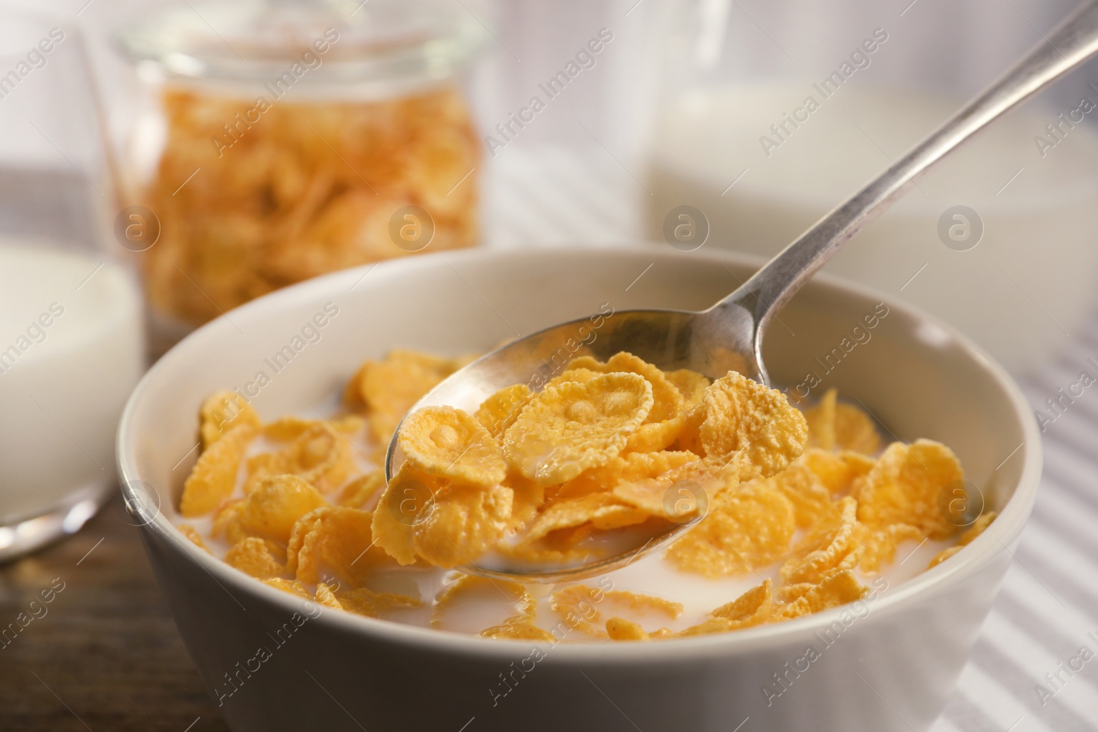 Photo of Healthy cornflakes with milk in bowl on table, closeup