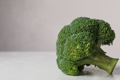 Photo of Fresh raw broccoli on white table, closeup. Space for text