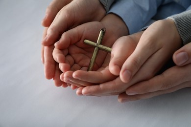 Photo of Boy and his godparents holding cross on white background, closeup