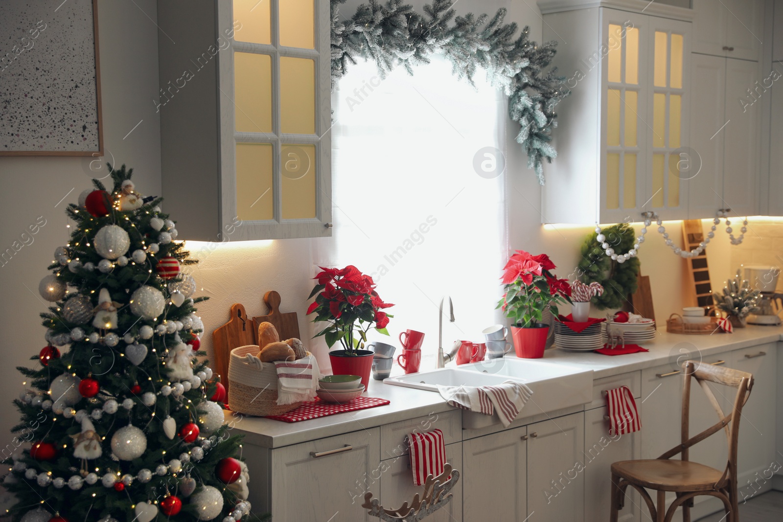 Photo of Beautiful kitchen interior with Christmas tree and festive decor