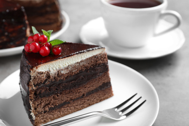 Photo of Tasty chocolate cake with berries on grey table, closeup