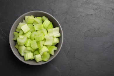 One bowl of fresh cut celery on grey table, top view. Space for text