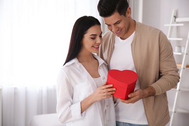 Lovely couple with gift box at home. Valentine's day celebration