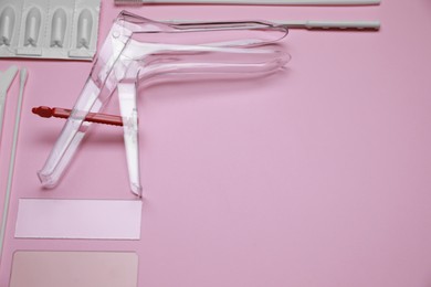 Photo of Sterile gynecological examination kit and medicaments on pink background, above view. Space for text