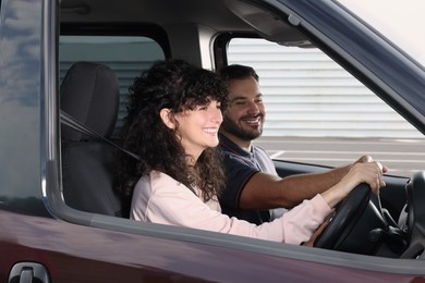 Photo of Driving school. Happy student during lesson with driving instructor in car