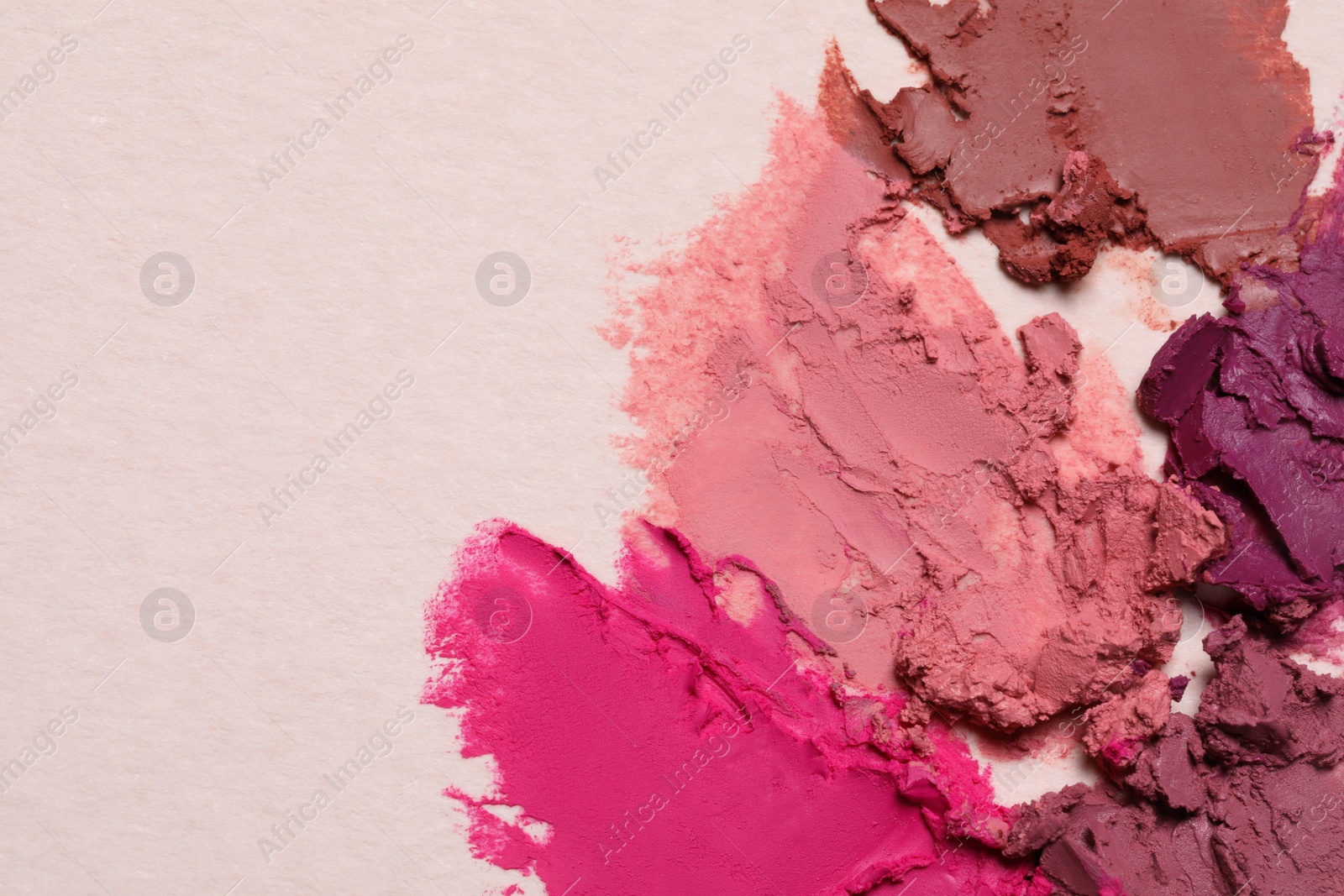 Photo of Smears of beautiful lipsticks on light background, top view. Space for text