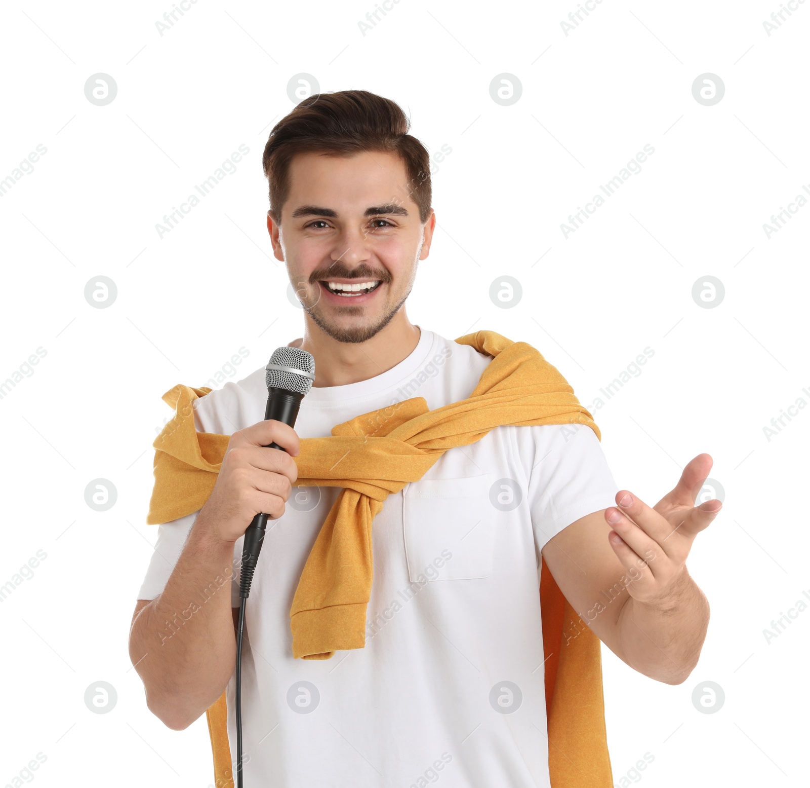 Photo of Young handsome man in casual clothes posing with microphone on white background