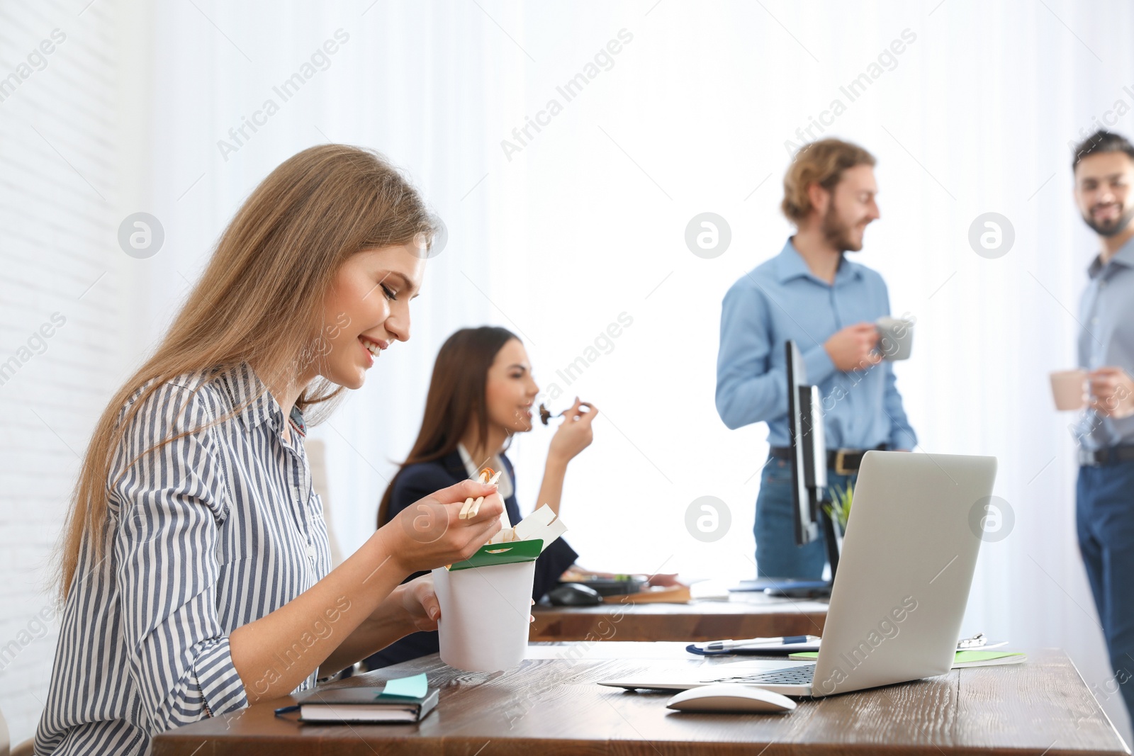 Photo of Office employees having lunch at workplace. Food delivery