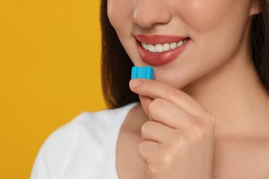 Photo of Woman with bubble gum on yellow background, closeup