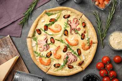 Photo of Delicious seafood pizza on grey table, flat lay