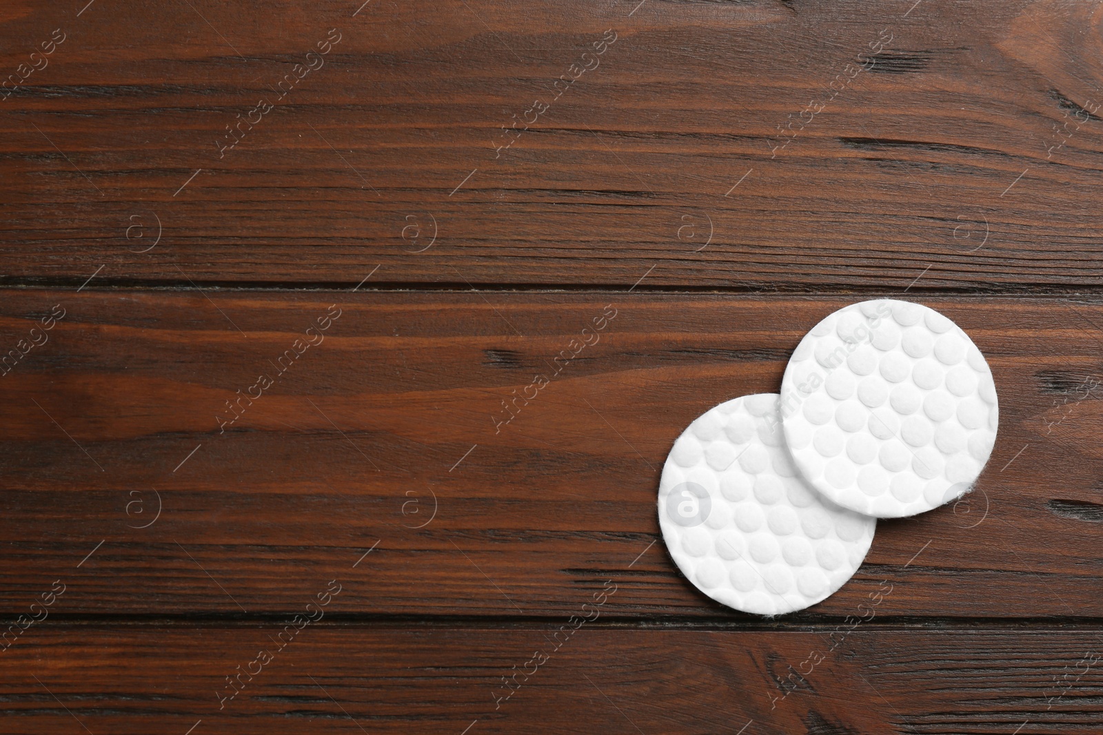 Photo of Cotton pads on wooden background, top view. Space for text