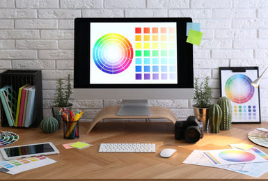 Photo of Modern computer and office supplies on wooden table. Designer's workplace