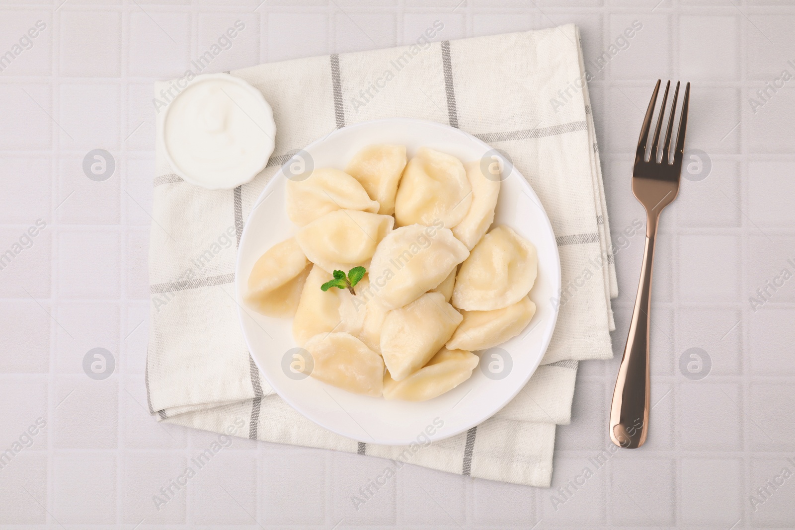 Photo of Delicious dumplings (varenyky) with cottage cheese served on white table, flat lay