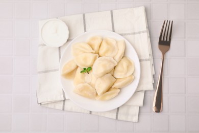 Photo of Delicious dumplings (varenyky) with cottage cheese served on white table, flat lay