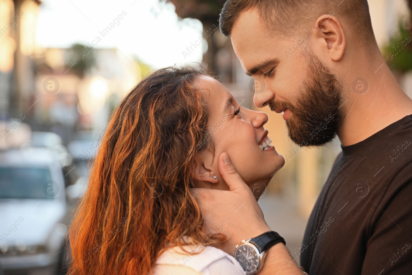 Photo of Happy young couple kissing on city street