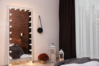 Photo of Large mirror with light bulbs in stylish room interior