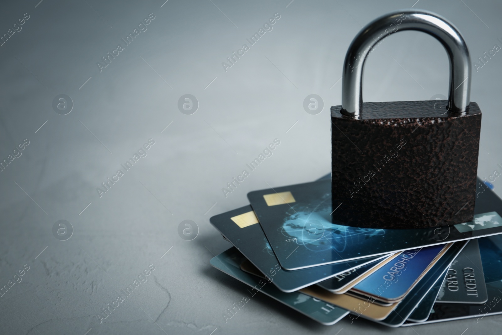 Photo of Credit cards and padlock on light grey background, space for text. Protection from cyber attack