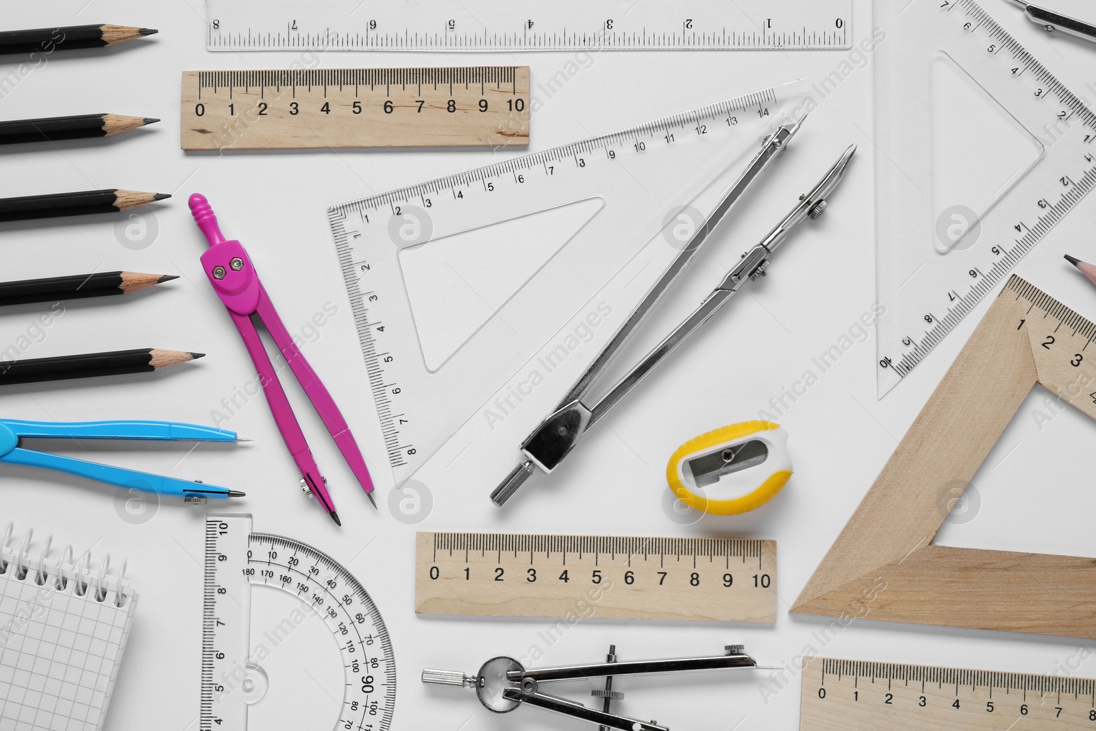 Photo of Flat lay composition with different rulers and compass on white background