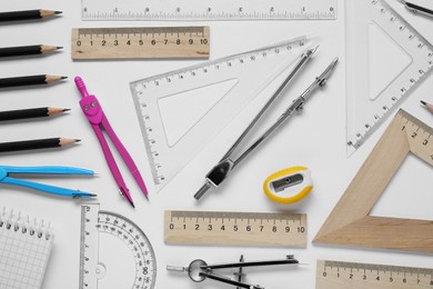 Flat lay composition with different rulers and compass on white background