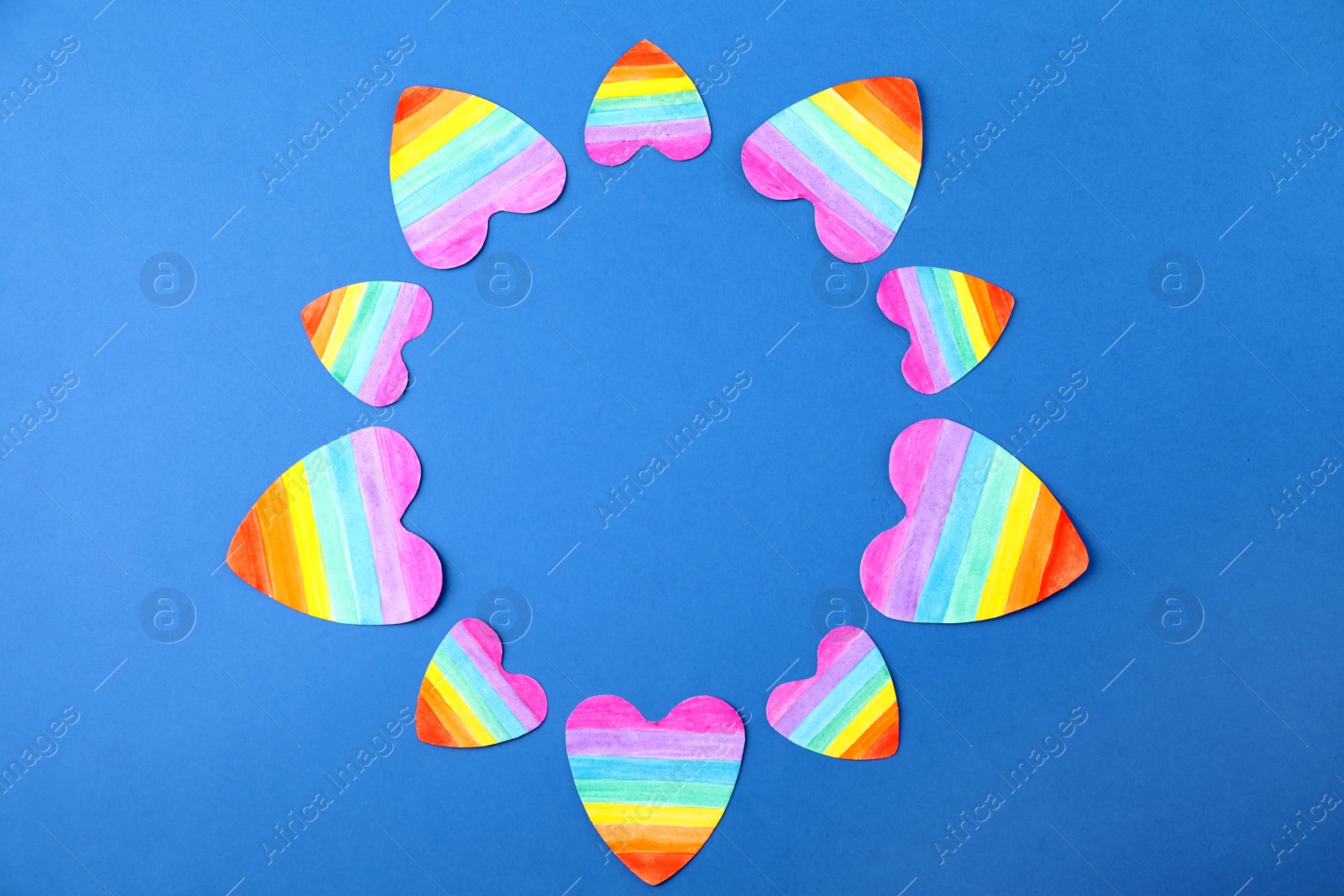 Photo of Top view of rainbow hearts on color background, space for text. Gay symbol
