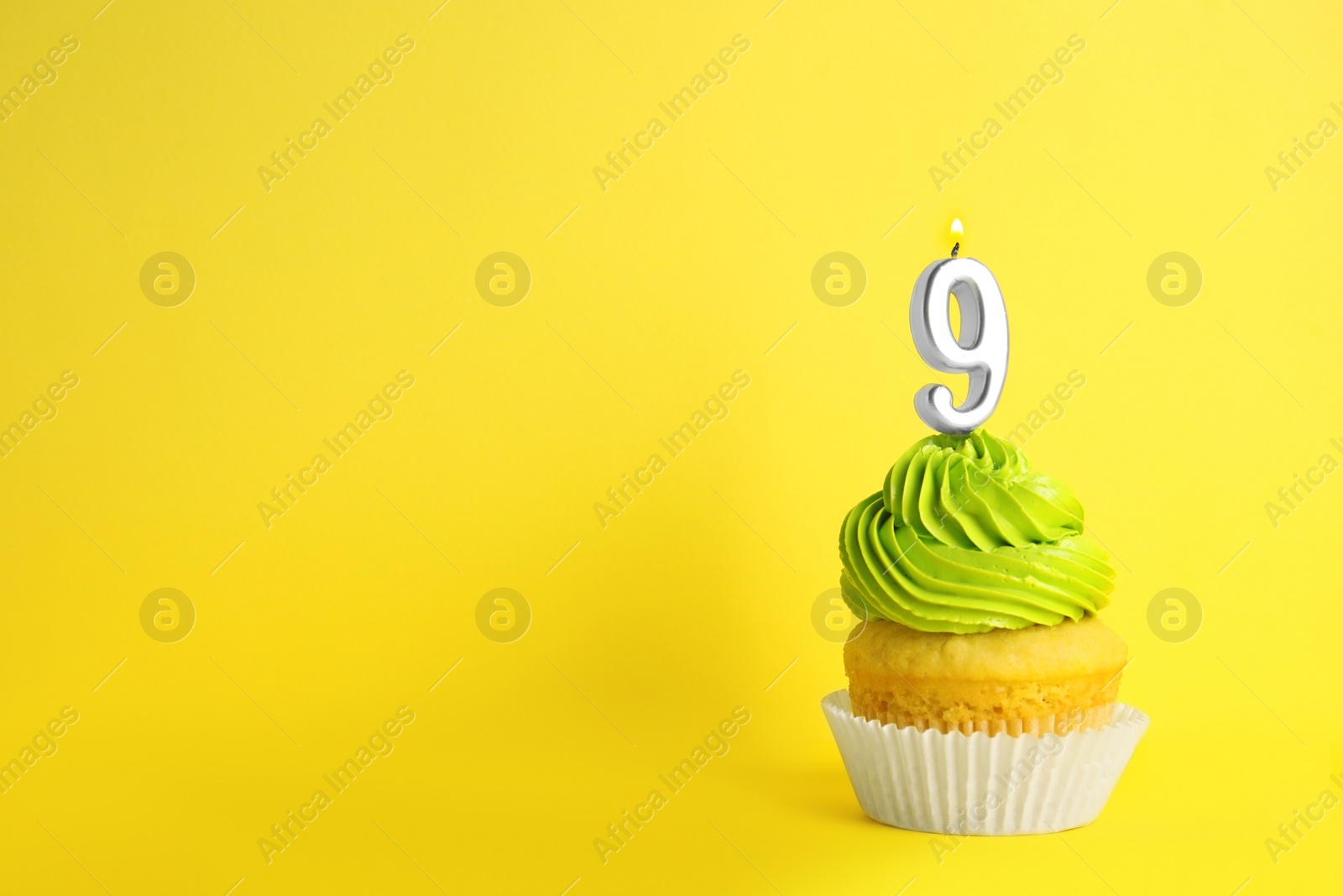 Photo of Birthday cupcake with number nine candle on yellow background, space for text