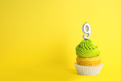 Photo of Birthday cupcake with number nine candle on yellow background, space for text