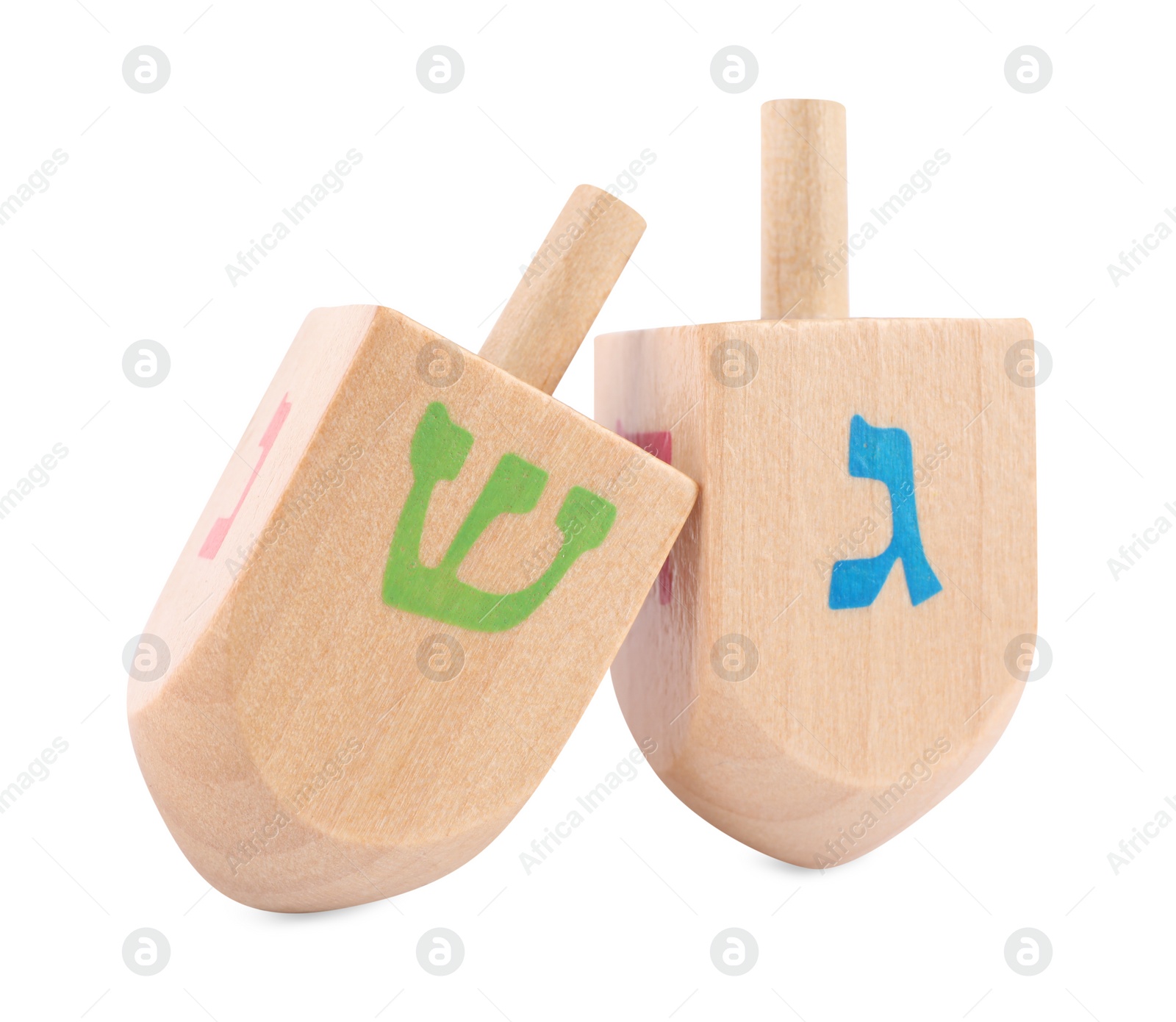 Photo of Hanukkah celebration. Wooden dreidels with jewish letters isolated on white