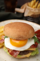 Photo of Delicious burger with fried egg on blurred background, closeup. Space for text