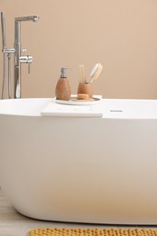 Different personal care products and accessories on bath tub in bathroom