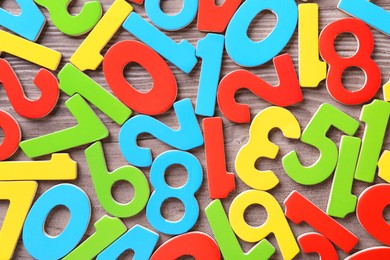 Photo of Colorful numbers on wooden school desk, top view