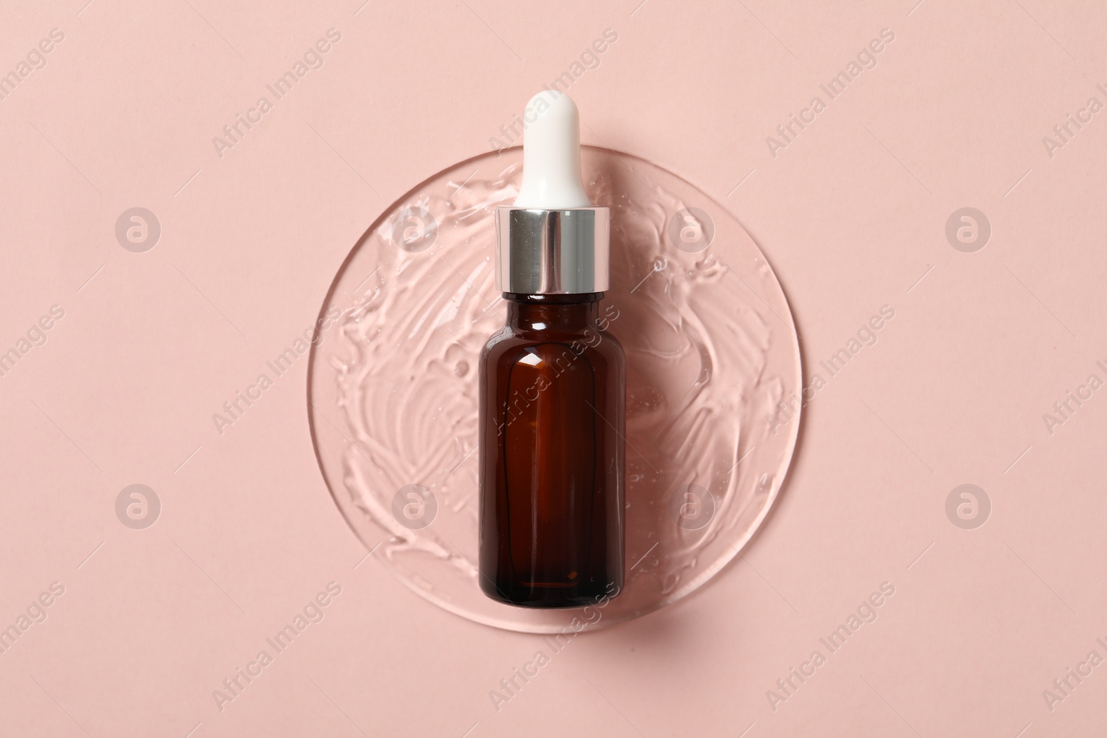 Photo of Bottle of cosmetic serum on pink background, top view