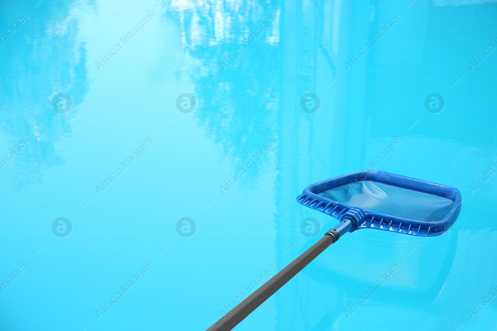 Photo of Cleaning outdoor pool with scoop net, closeup