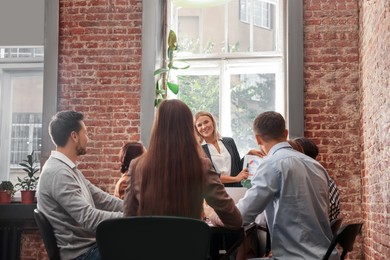 Photo of Businesswoman having meeting with her employees in office. Lady boss