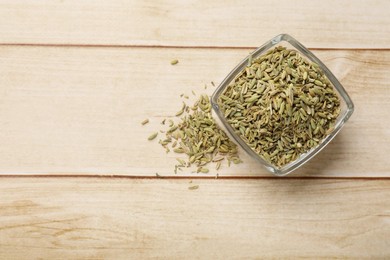 Photo of Bowl with fennel seeds on wooden table, top view. Space for text