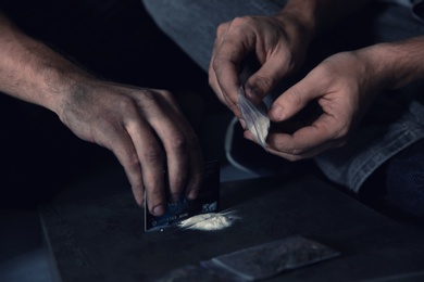 Photo of Young addicted men taking drugs, closeup of hands