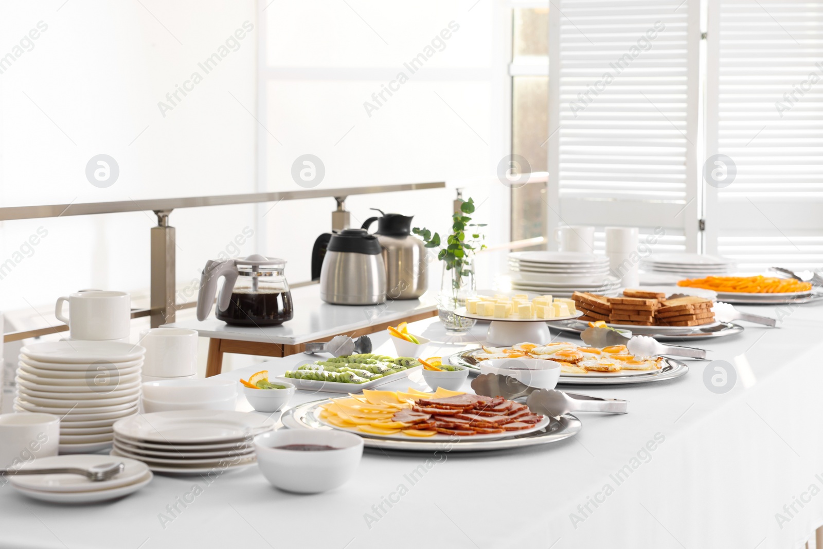 Photo of Clean dishware and different meals for breakfast on white table indoors. Buffet service