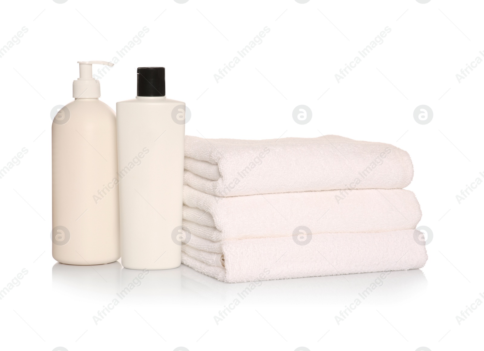 Photo of Folded soft terry towels with cosmetic products on white background