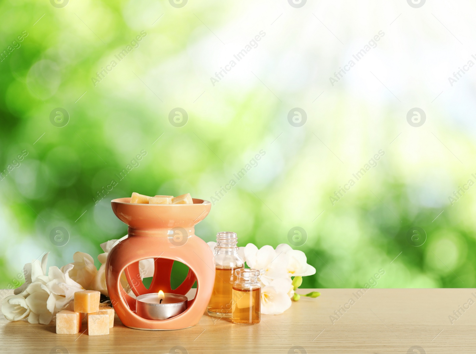 Image of Composition with aroma lamp on wooden table outdoors, space for text. Bokeh effect