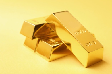 Precious shiny gold bars on color background