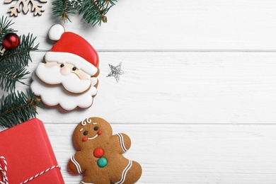 Flat lay composition with tasty homemade Christmas cookies on white wooden table, space for text