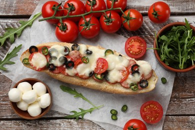 Photo of Tasty pizza toast and ingredients on wooden table, top view