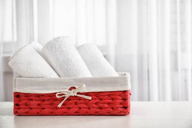 Photo of Basket with clean towels on table