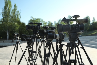 Photo of Modern professional video cameras outdoors on sunny day