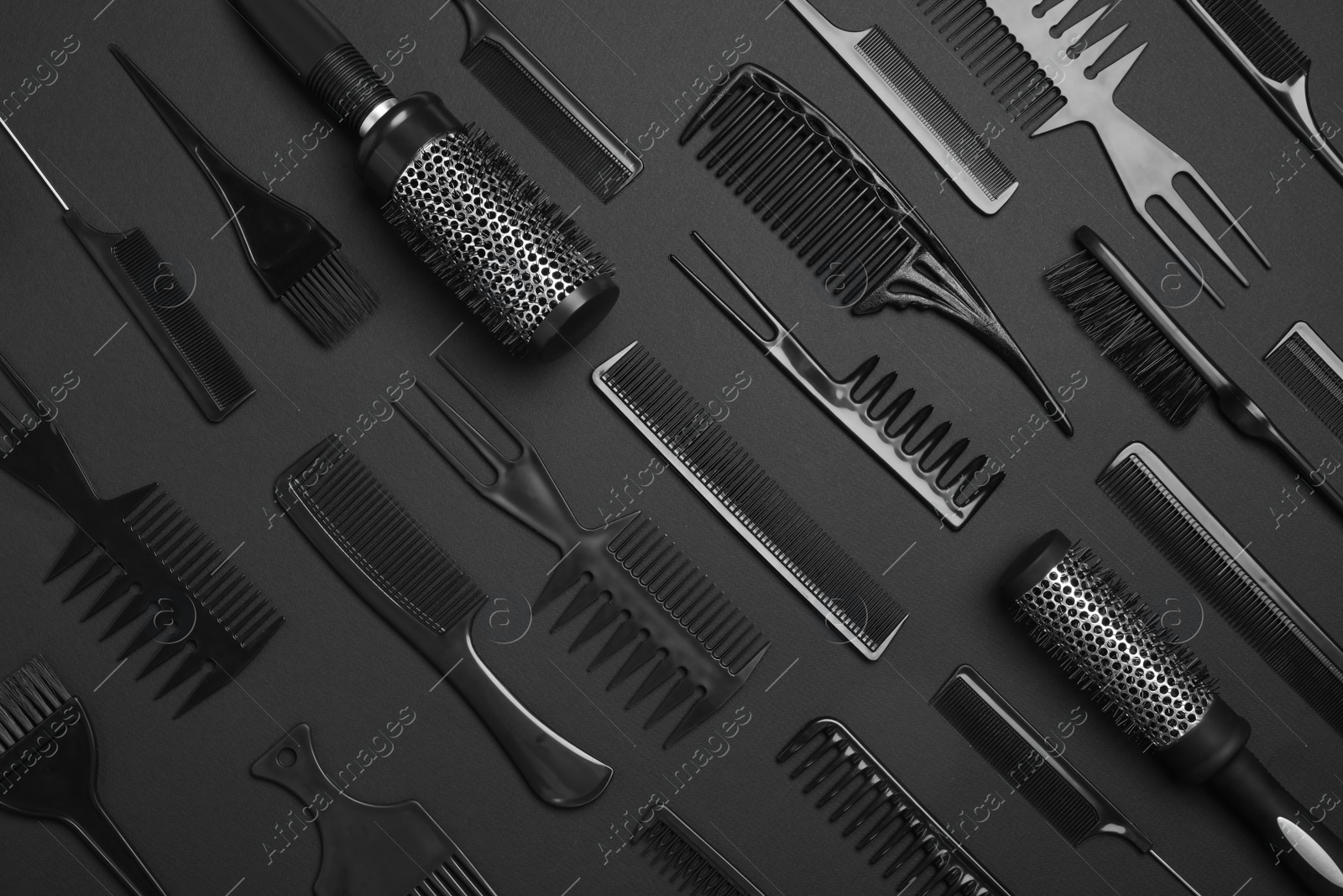 Photo of Flat lay composition with modern hair combs and brushes on black background