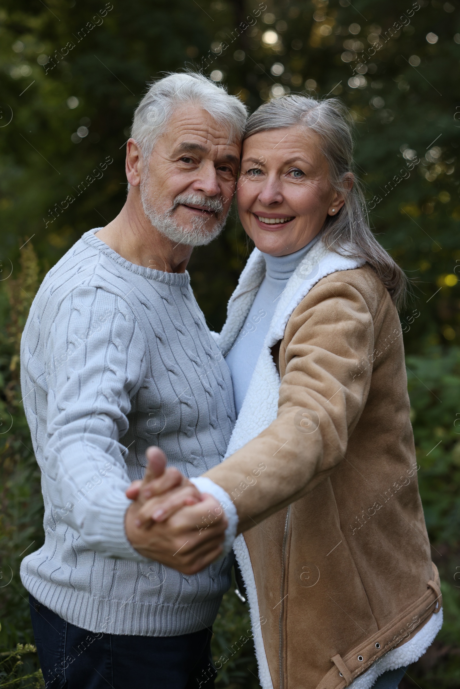 Photo of Affectionate senior couple dancing together outdoors. Romantic date