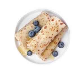 Photo of Delicious crepes with blueberries and honey on white background, top view