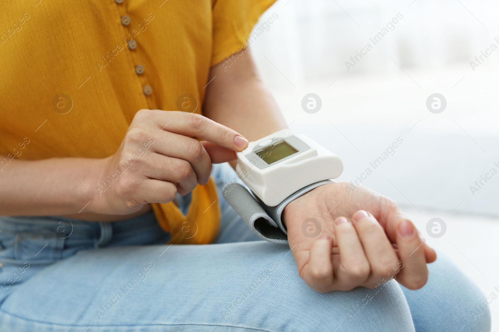 Photo of Woman checking blood pressure with sphygmomanometer at home, closeup. Cardiology concept