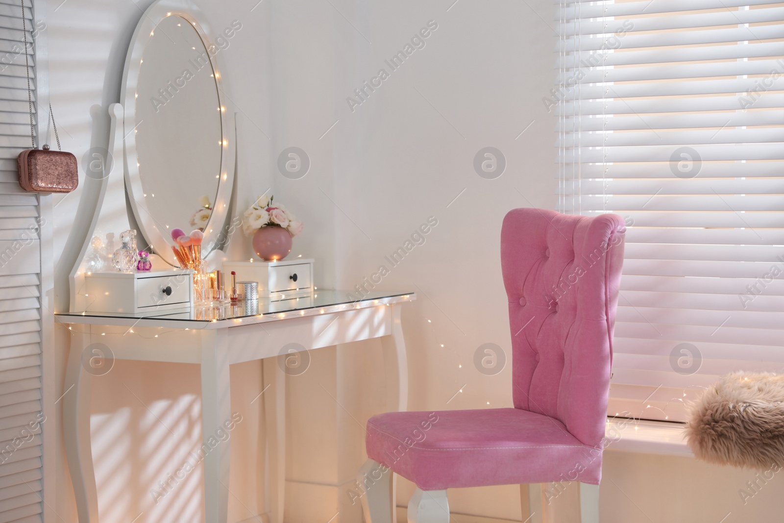 Photo of Elegant dressing table with lights and pink chair in stylish room interior