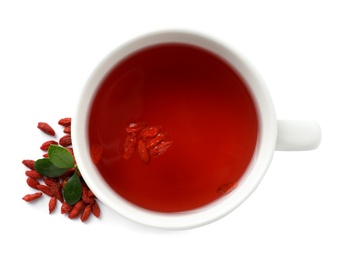 Photo of Healthy goji tea in cup with berries on white background, top view