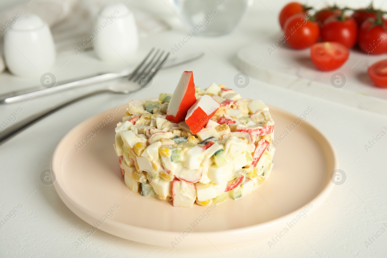 Photo of Delicious salad with fresh crab sticks on white table